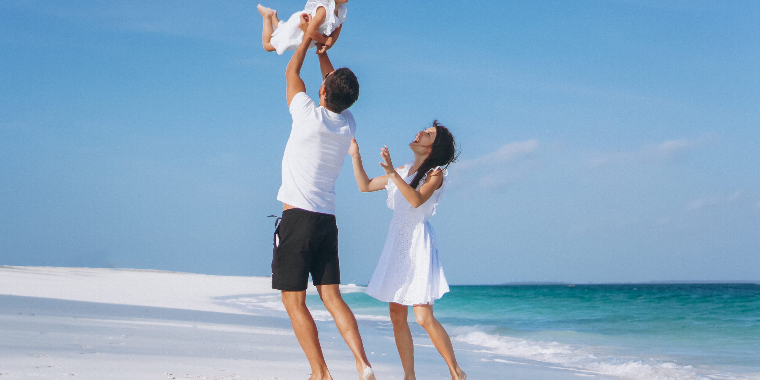 Young family with little daugher on a vacation by the ocean